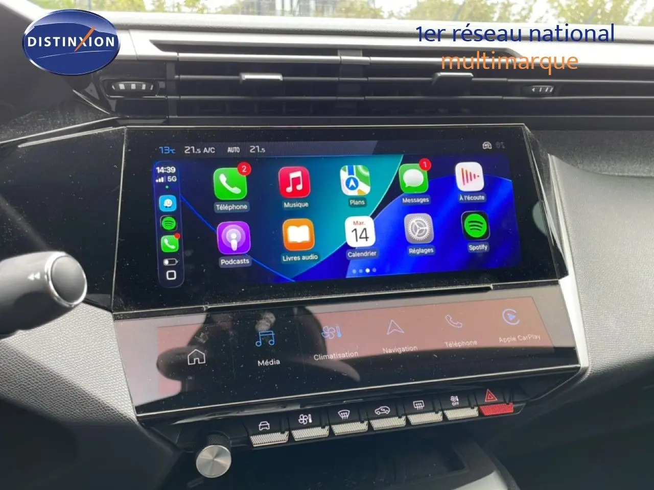 Écran tactile central de la Peugeot 408 2025, affichant Apple CarPlay avec interface colorée et commandes intégrées.