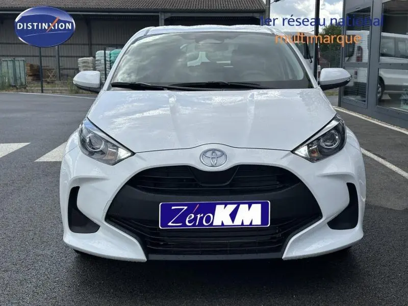 Vue avant d'une Toyota Yaris 116h Dynamic blanche Lunaire avec calandre noire et phares LED visibles.