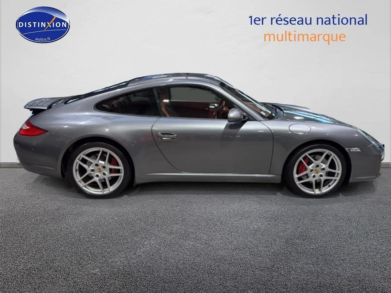 Profil droit d'une Porsche 911 (997) Carrera PDK gris métallisé avec jantes alu et toit ouvrant électrique visible.