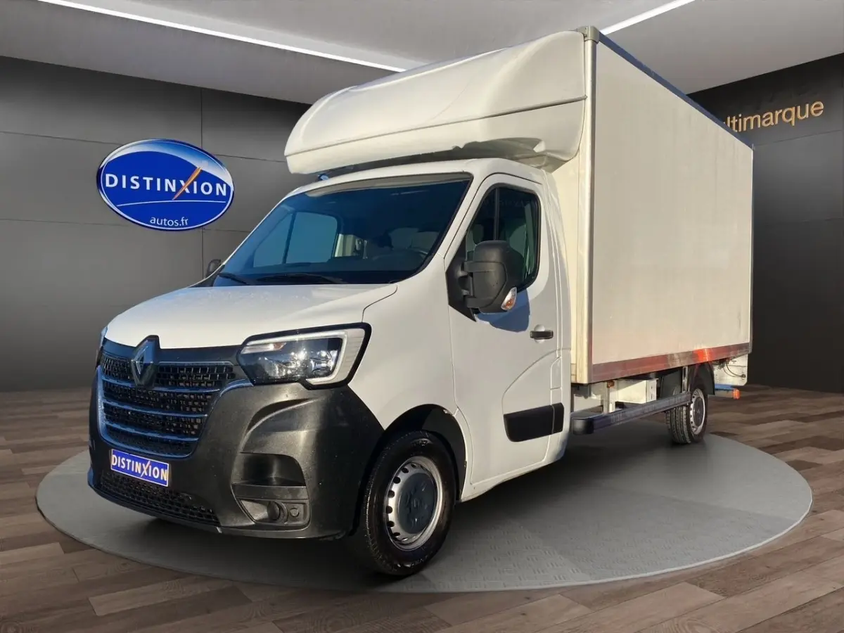 Renault Master blanc en 3/4 avant droit avec caisse hayon, calandre noire et jantes acier visibles.