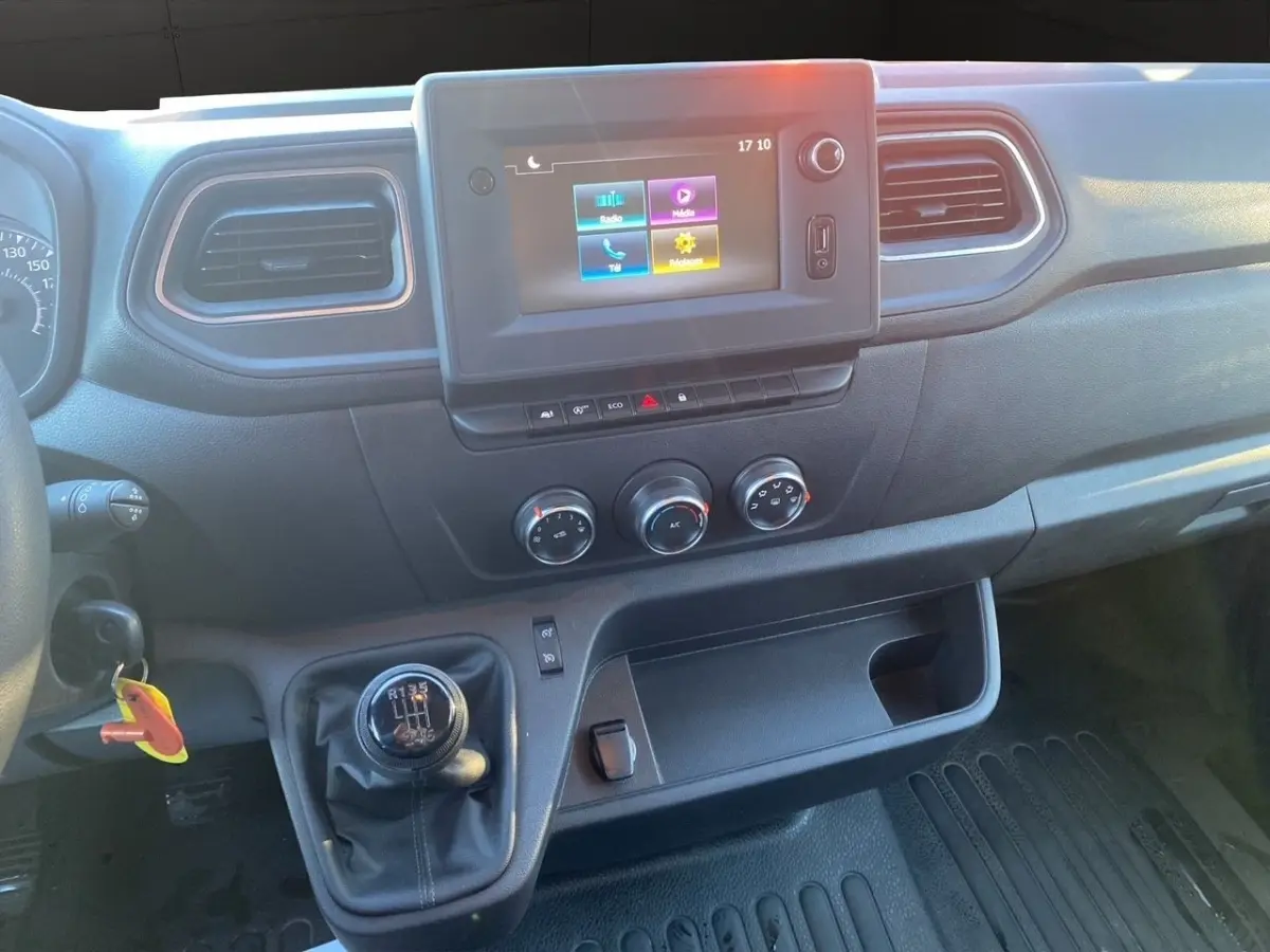 Vue intérieure du tableau de bord du Renault Master blanc 2023, avec écran tactile et levier de vitesse manuel visible.