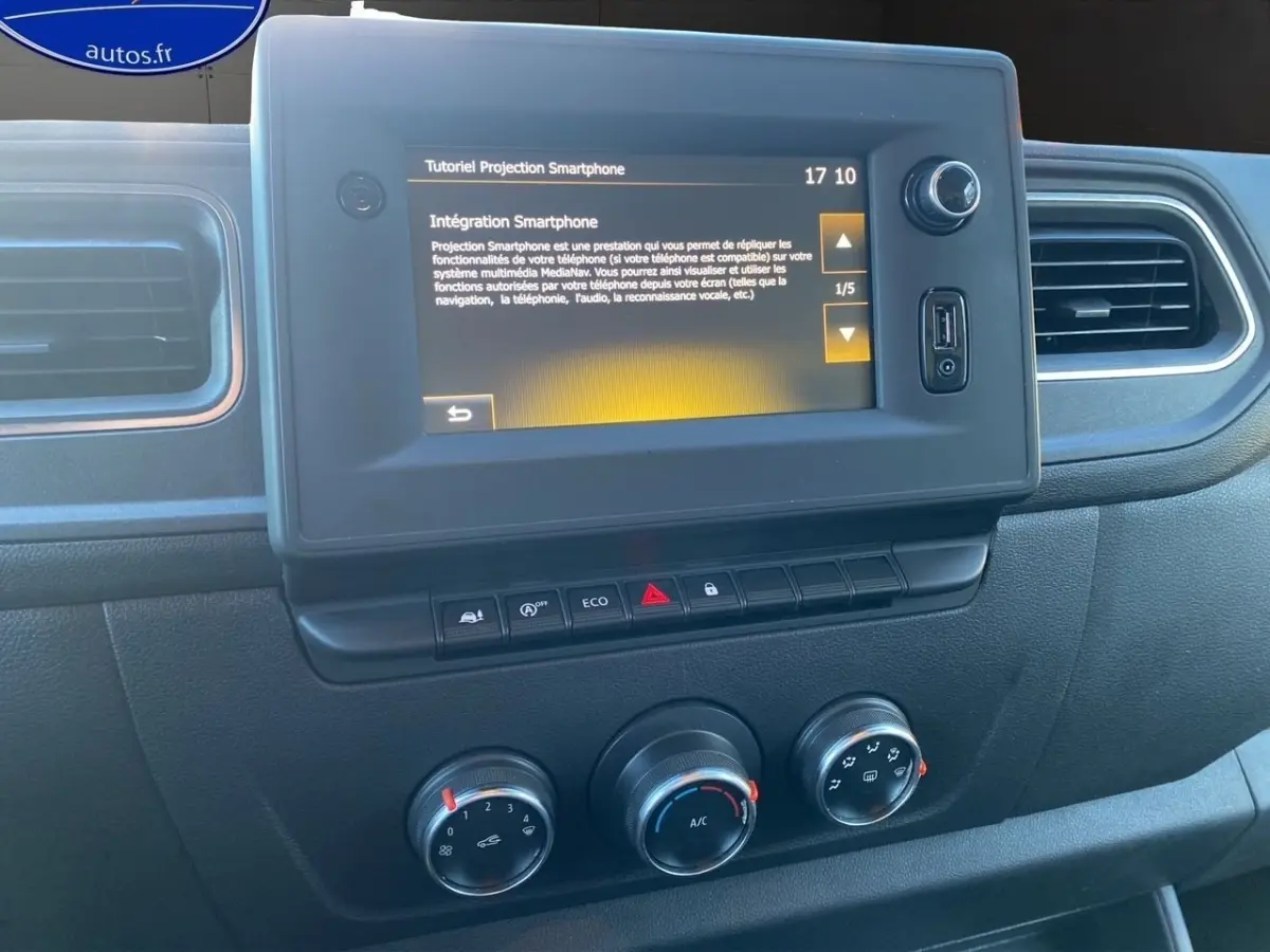 Tableau de bord du Renault Master 2023 avec écran tactile central affichant un tutoriel smartphone, boutons de commande et réglages climatisation.
