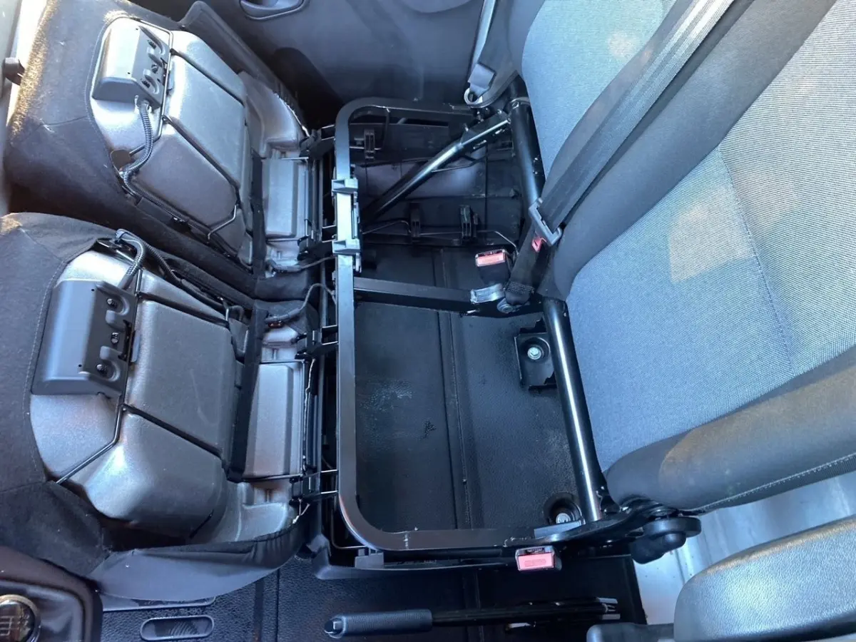 Vue intérieure rapprochée des sièges arrière rabattus du Renault Master 2023, montrant la structure métallique et les ceintures grises.