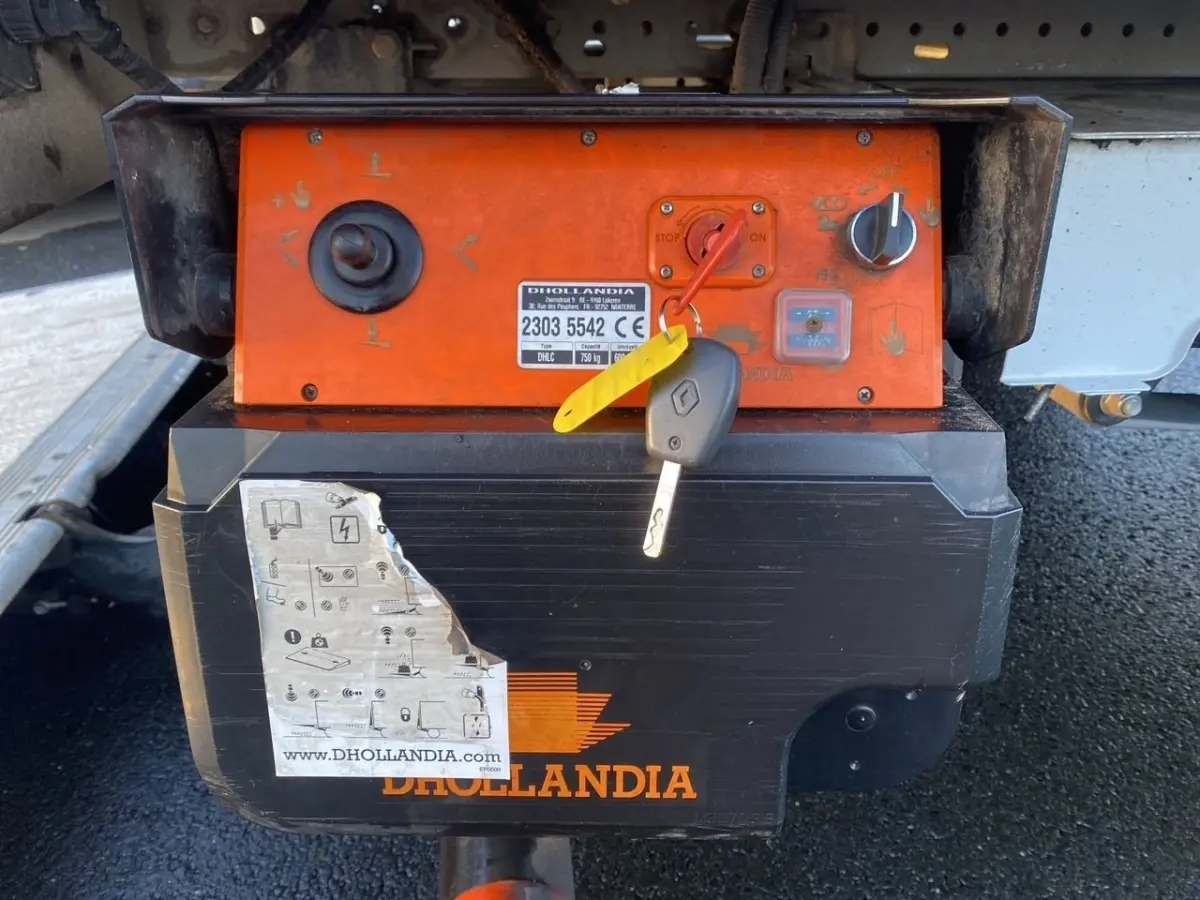 Gros plan sur le boîtier de commande orange et noir du hayon arrière du Renault Master blanc, avec clé insérée.