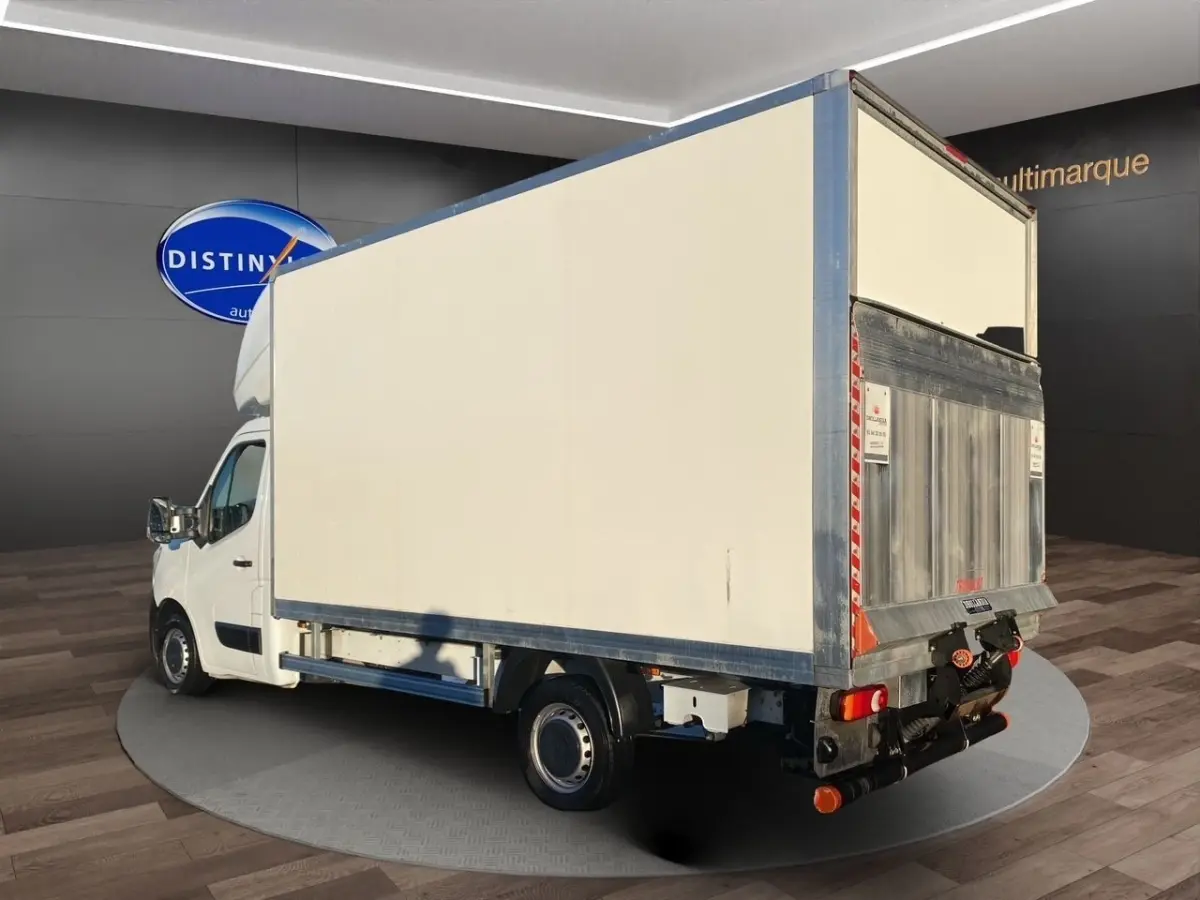 Renault Master blanc en 3/4 arrière droit, châssis cabine avec hayon élévateur métallique visible.
