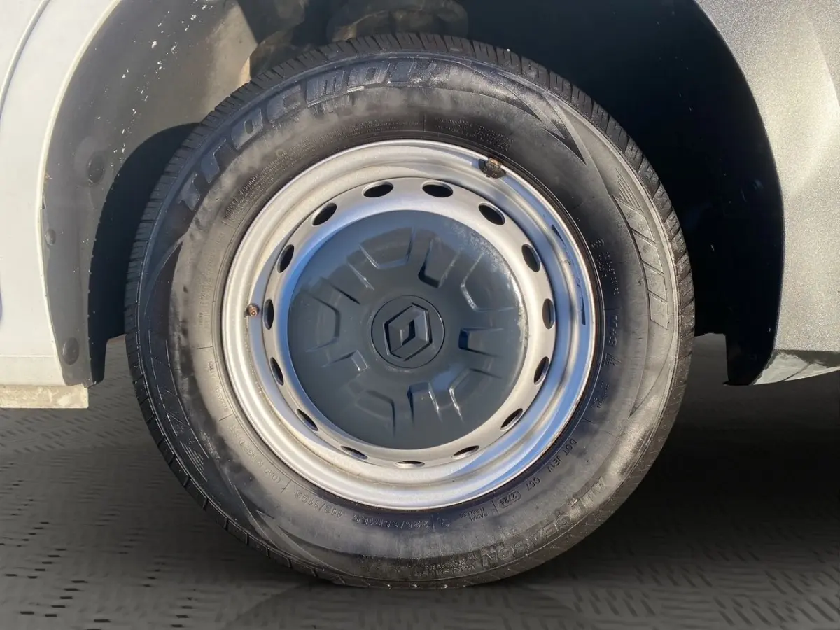 Gros plan sur la roue avant gauche du Renault Master blanc, jante acier avec enjoliveur marqué du logo Renault.