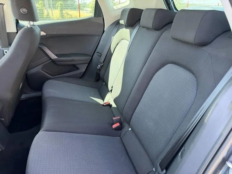 Vue intérieure côté droit de la banquette arrière en tissu gris Como du SEAT Arona 2025 avec appuie-têtes et ceintures visibles.