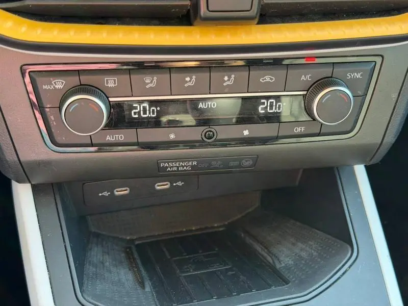 Vue rapprochée de la console centrale du SEAT Arona 2025, montrant la climatisation automatique et les ports USB.
