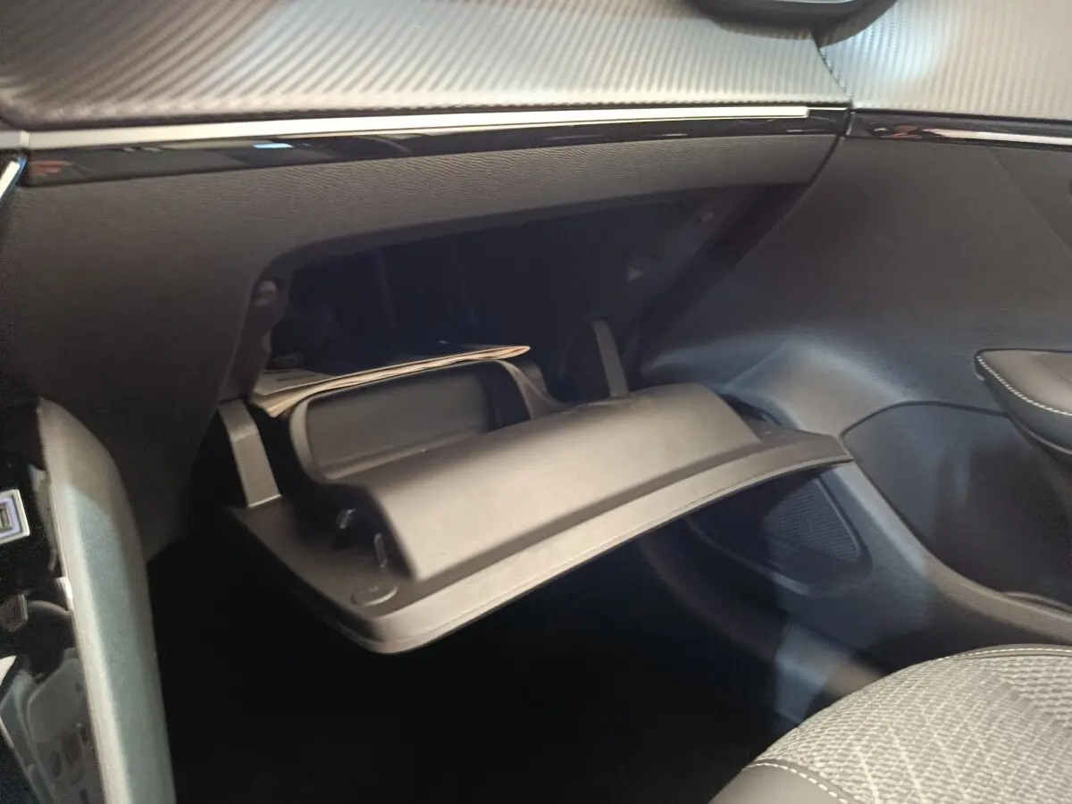 Vue intérieure du coffre à gants ouvert côté passager de la Peugeot 208 électrique blanche 2024.