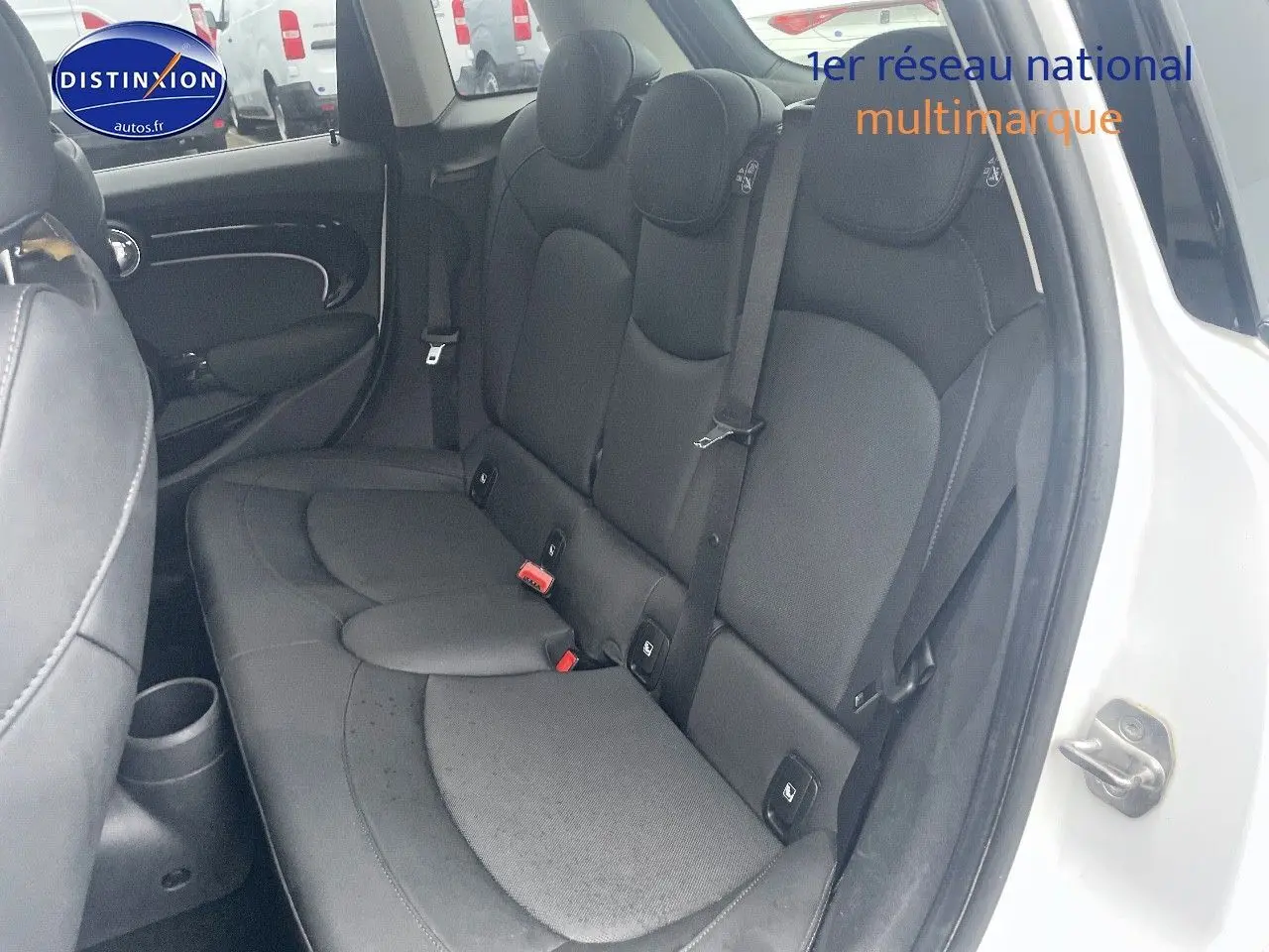 Vue intérieure côté droit sur la banquette arrière en cuir noir d'une MINI blanc nacré 2023 à cinq portes.