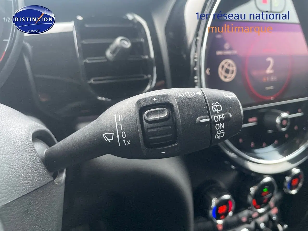 Gros plan sur la commande d’essuie-glace à gauche du volant dans l’habitacle noir d’une MINI blanche nacrée 2023.