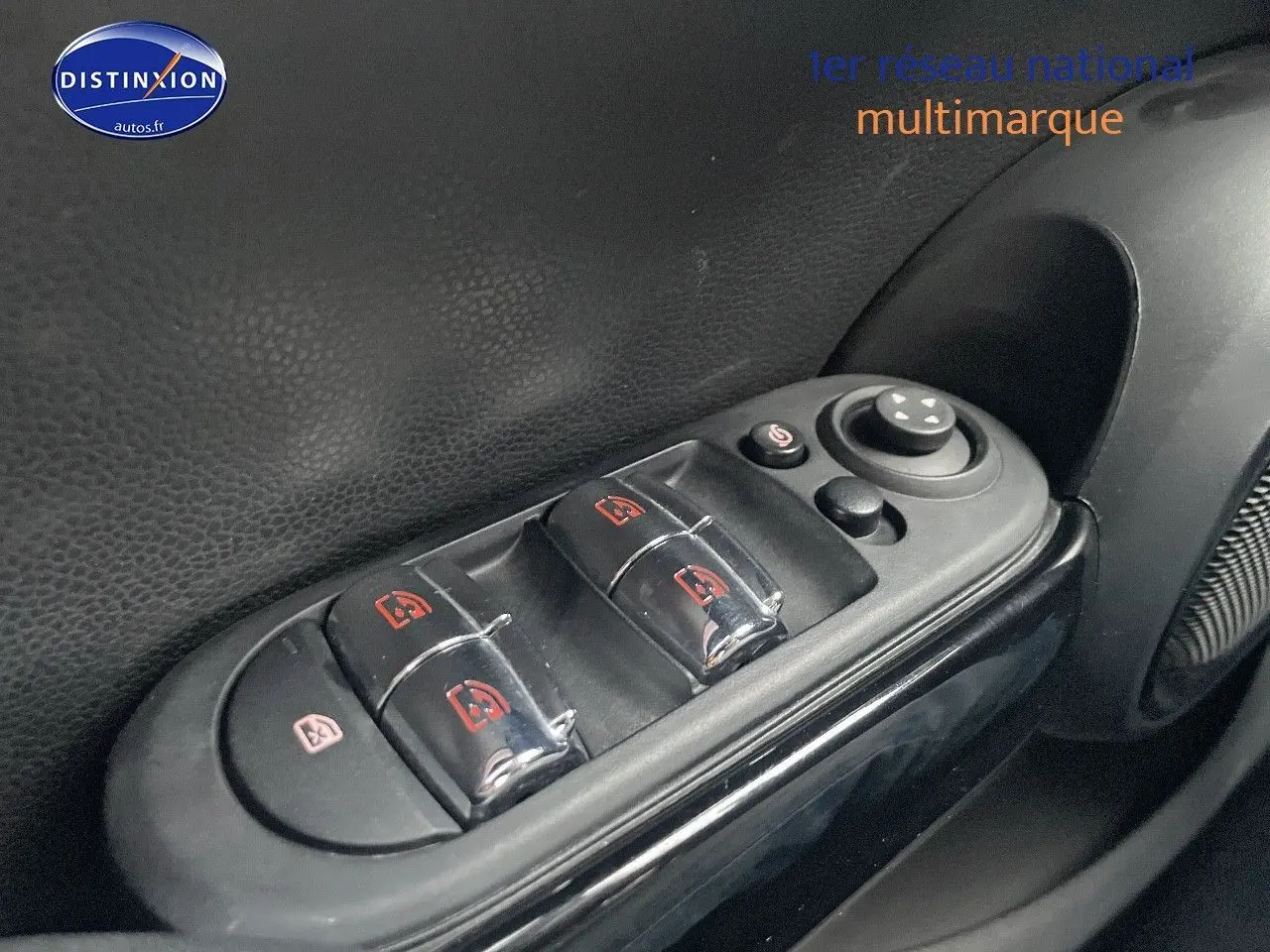 Gros plan sur les commandes des vitres électriques côté conducteur d'une MINI blanche nacrée 2023.