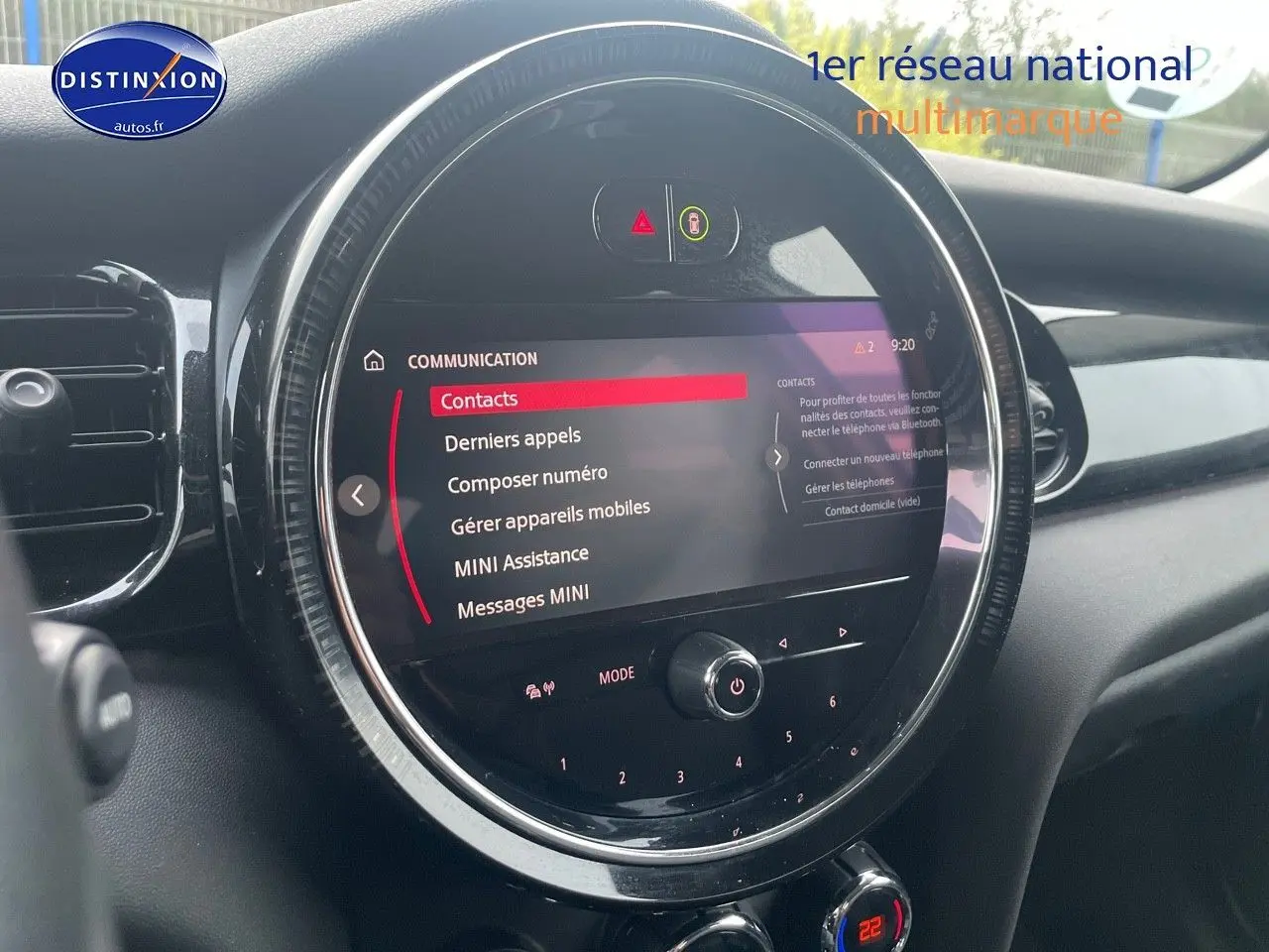 Vue rapprochée de l'écran central tactile circulaire du tableau de bord d'une MINI blanche nacrée 2023.