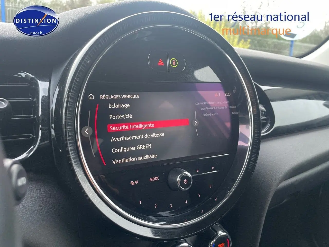 Écran central rond affichant les réglages de sécurité dans l'habitacle d'une MINI blanche nacrée 2023.