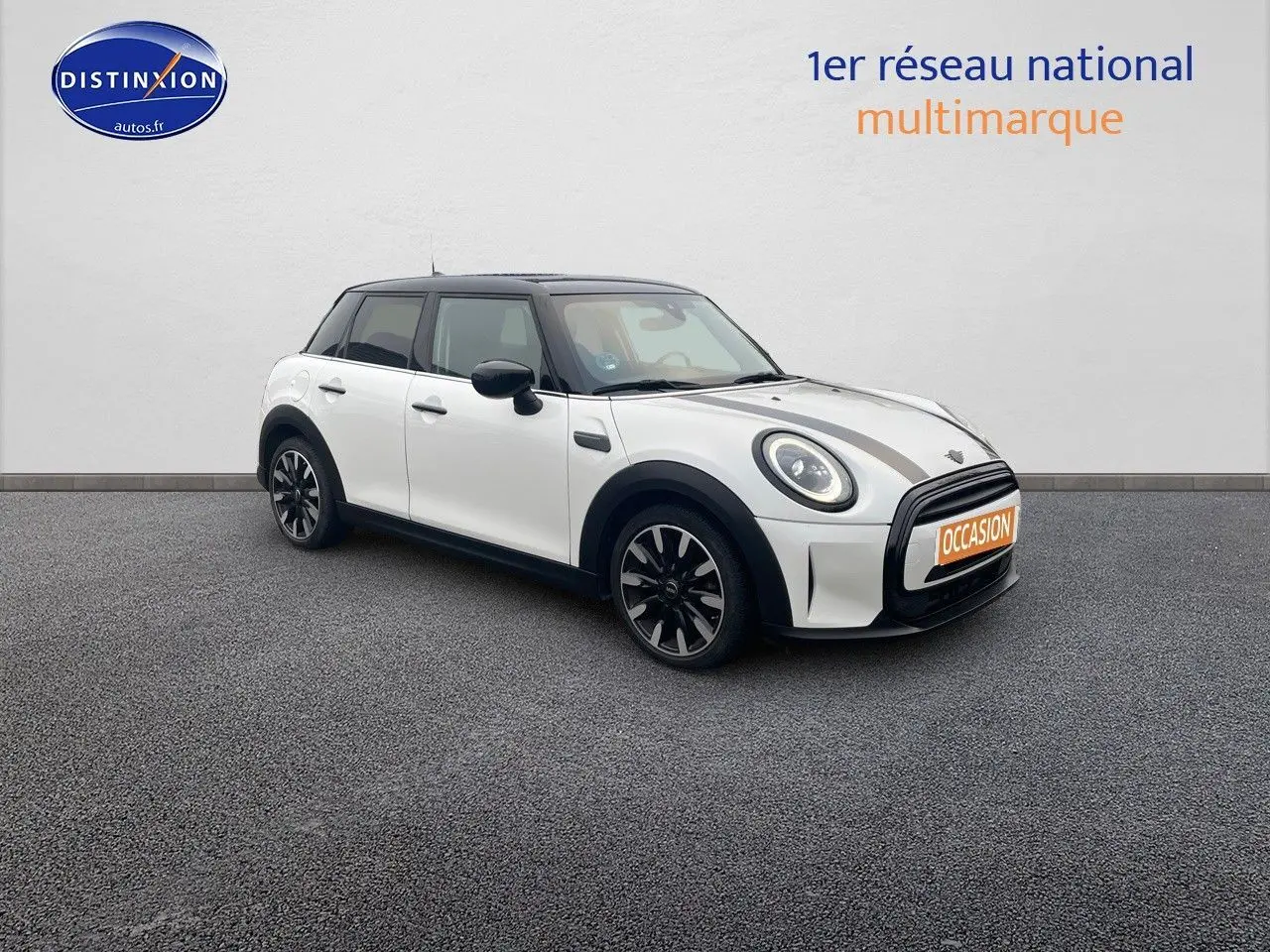 Vue 3/4 avant droit d'une MINI 1.5 136CH blanche nacrée avec toit noir et jantes bi-ton sur sol gris.