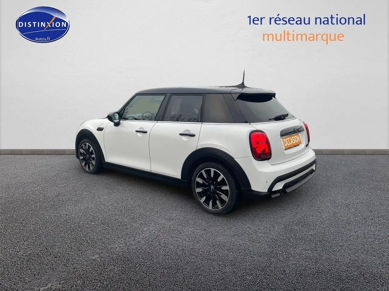 Vue 3/4 arrière droite d'une MINI 1.5 136CH blanche nacrée avec toit noir et jantes bi-ton.