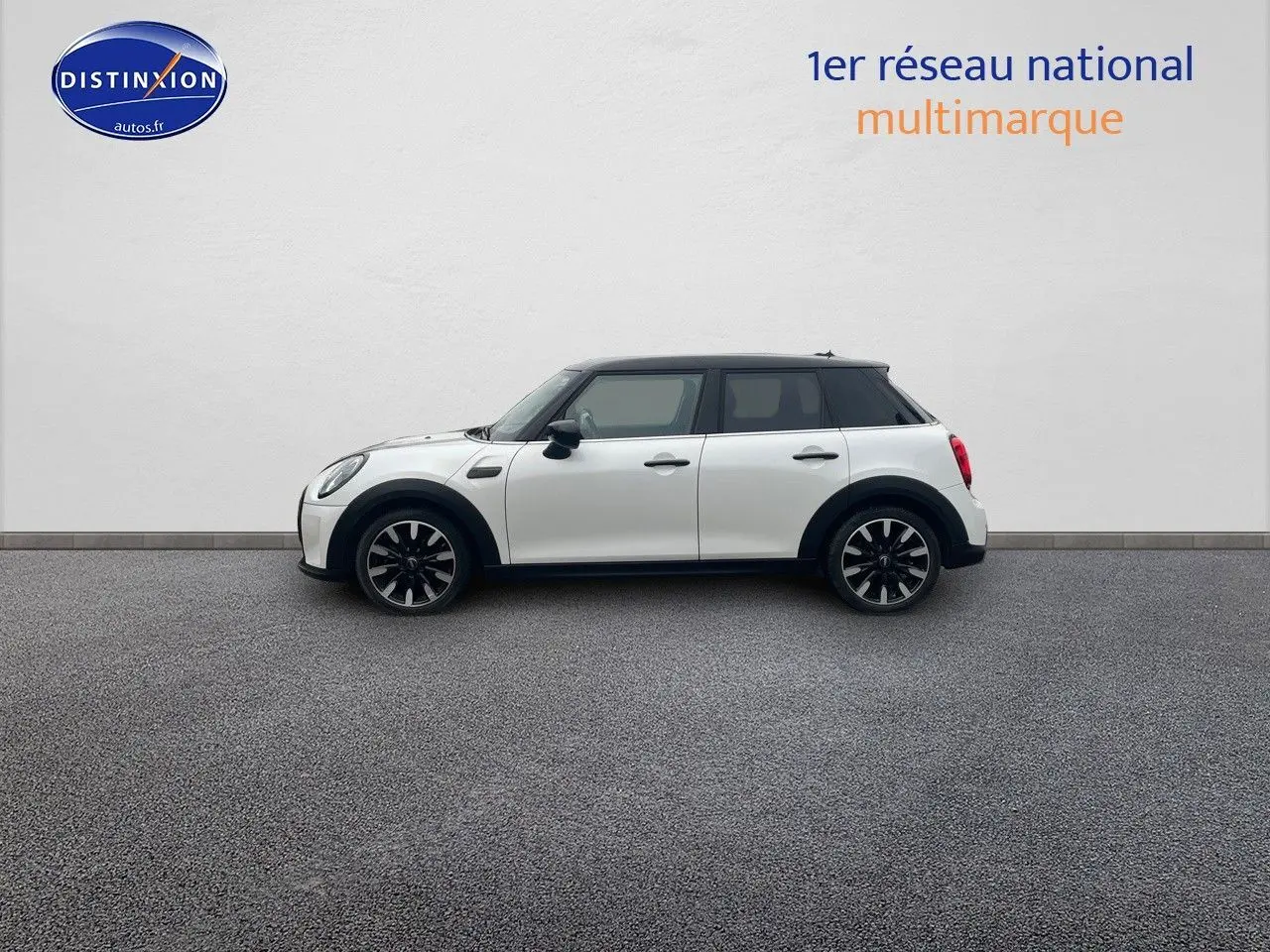 Profil droit d'une MINI 1.5 136CH STEPTRONIC blanc nacré avec toit noir et jantes bi-ton sur fond neutre.