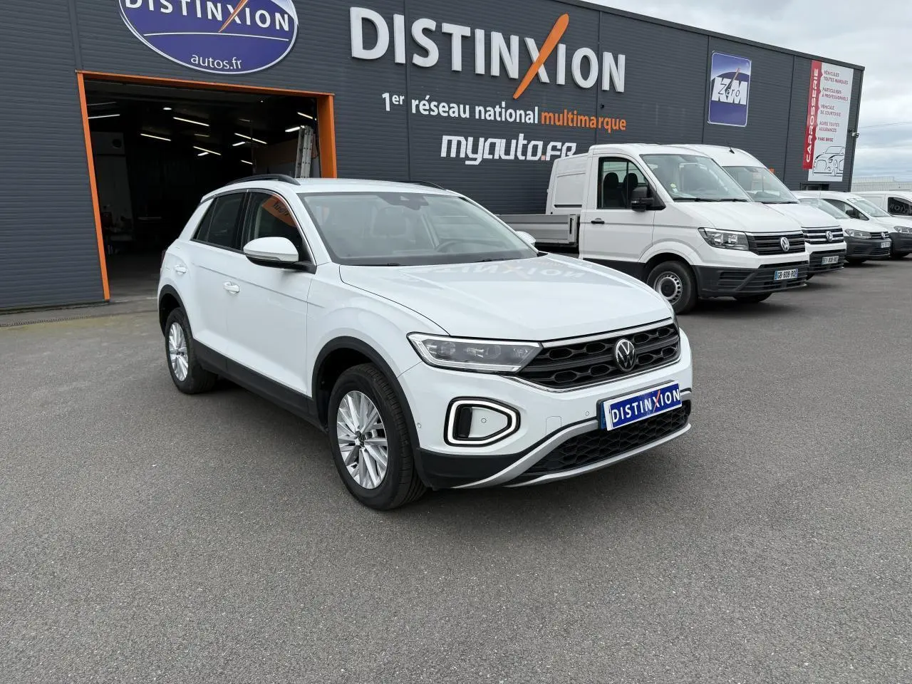 Volkswagen T-Roc blanc pur vu en 3/4 avant droit devant un garage Distinxion