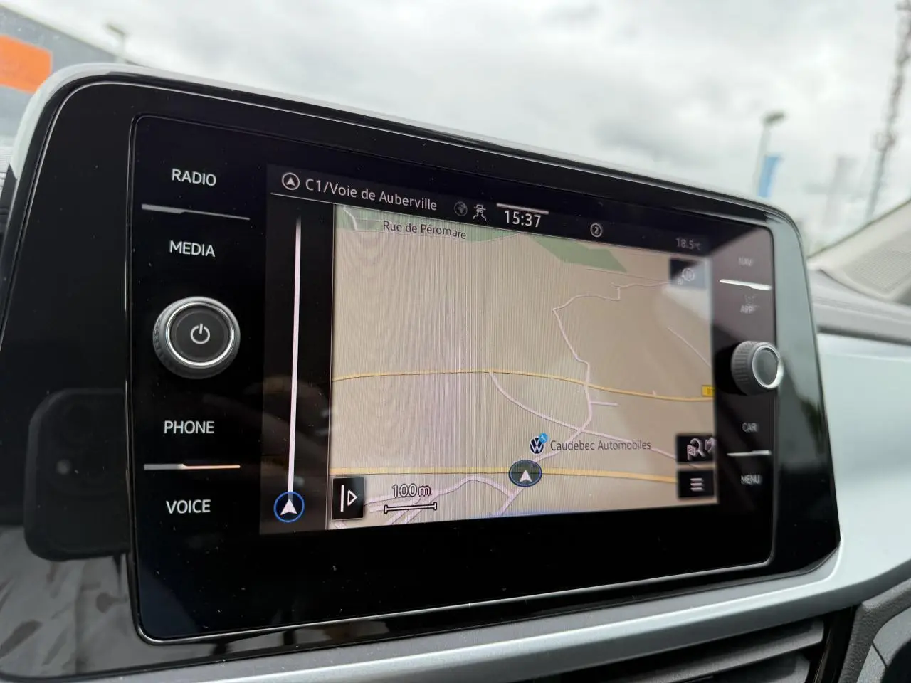 Écran tactile du système de navigation du Volkswagen T-Roc blanc, vue intérieure centrée sur la carte GPS.