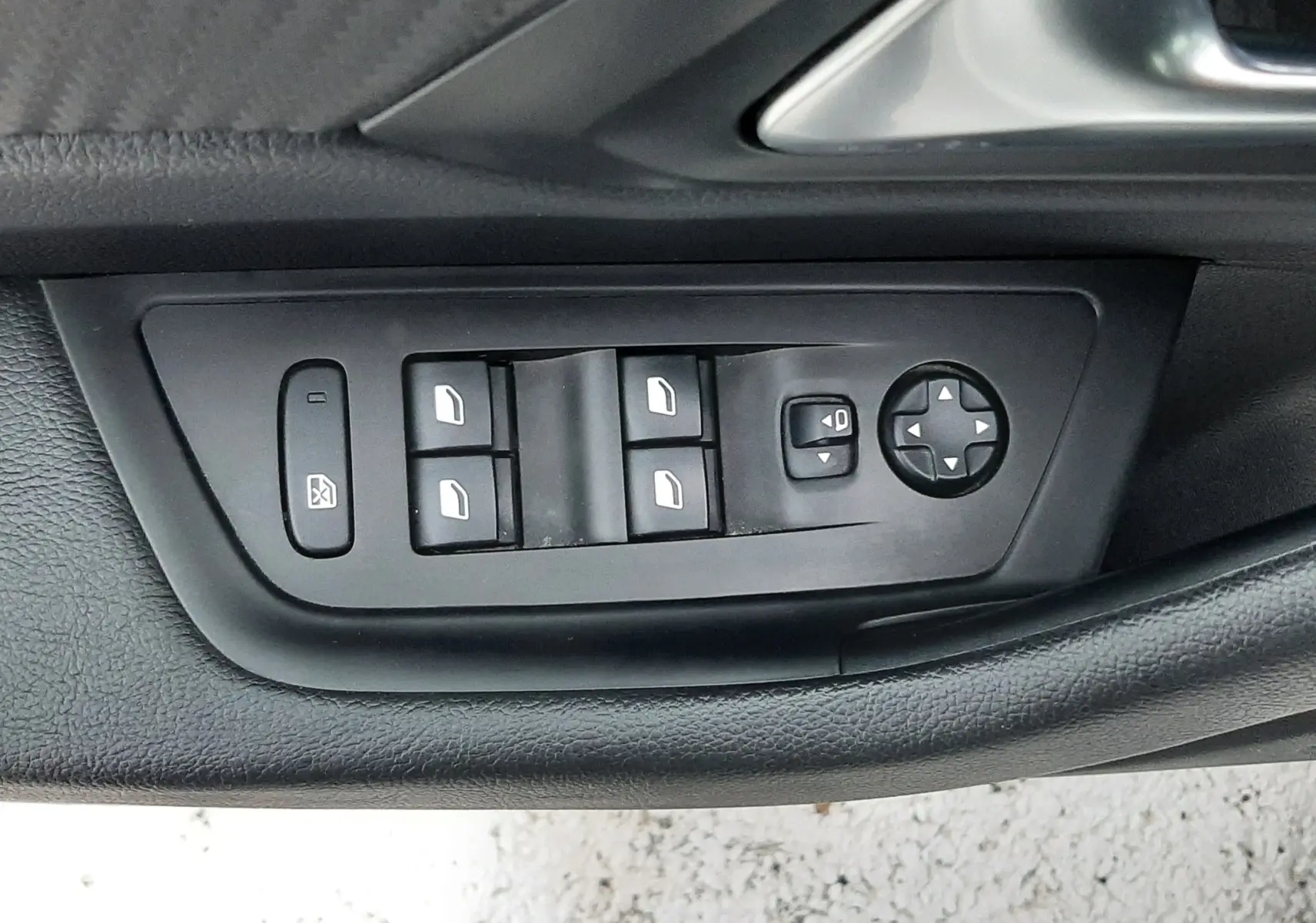 Gros plan sur les commandes de lève-vitres et réglage des rétroviseurs côté conducteur de la Peugeot 508 blanche.