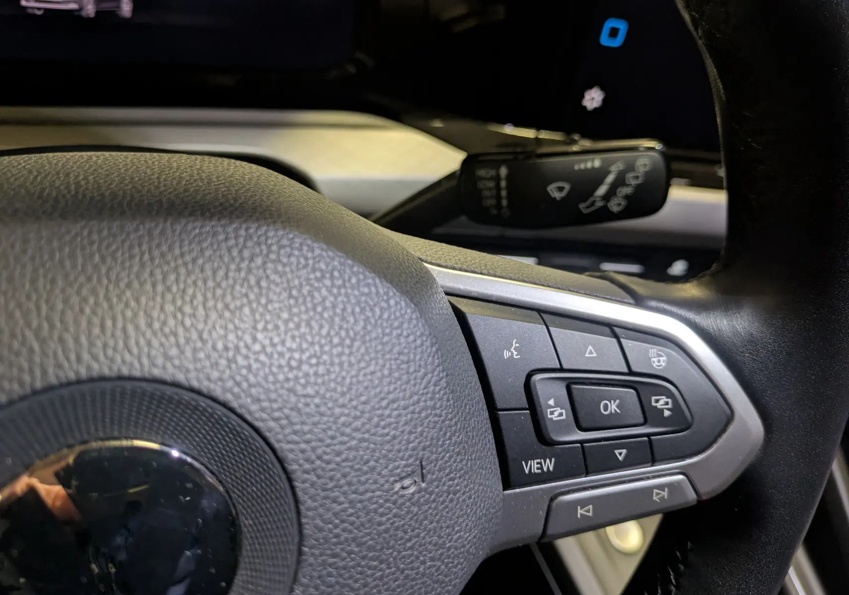 Gros plan sur le volant noir de la Volkswagen Golf 1.5 eTSI 2024, avec commandes multifonctions visibles côté droit.