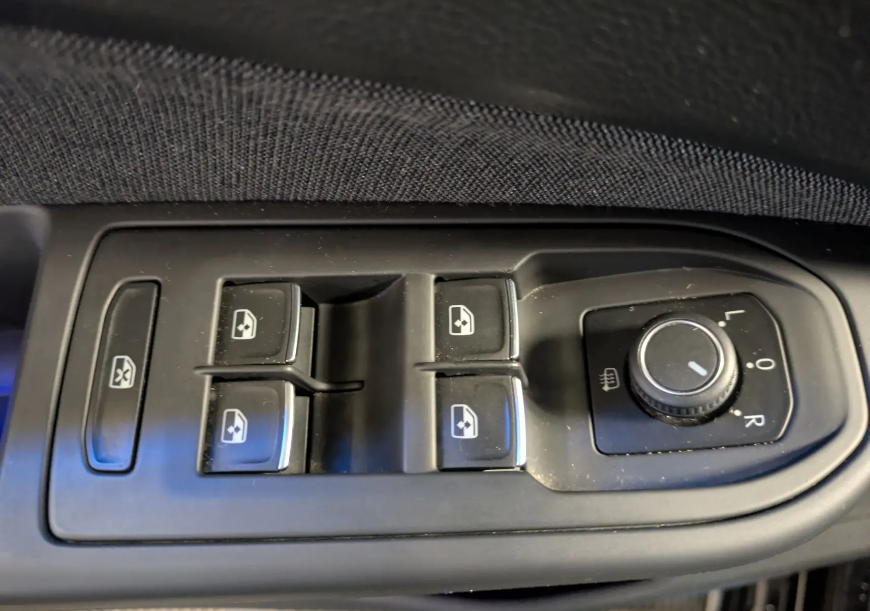 Commande des vitres électriques et réglage des rétroviseurs côté conducteur d'une Volkswagen Golf 2024 noire.