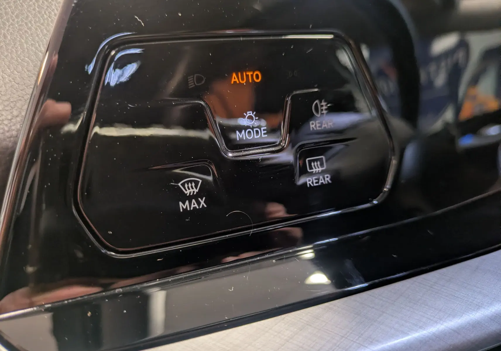 Gros plan sur les commandes de l’éclairage et dégivrage arrière de la Volkswagen Golf 1.5 eTSI Style 2024 noire.