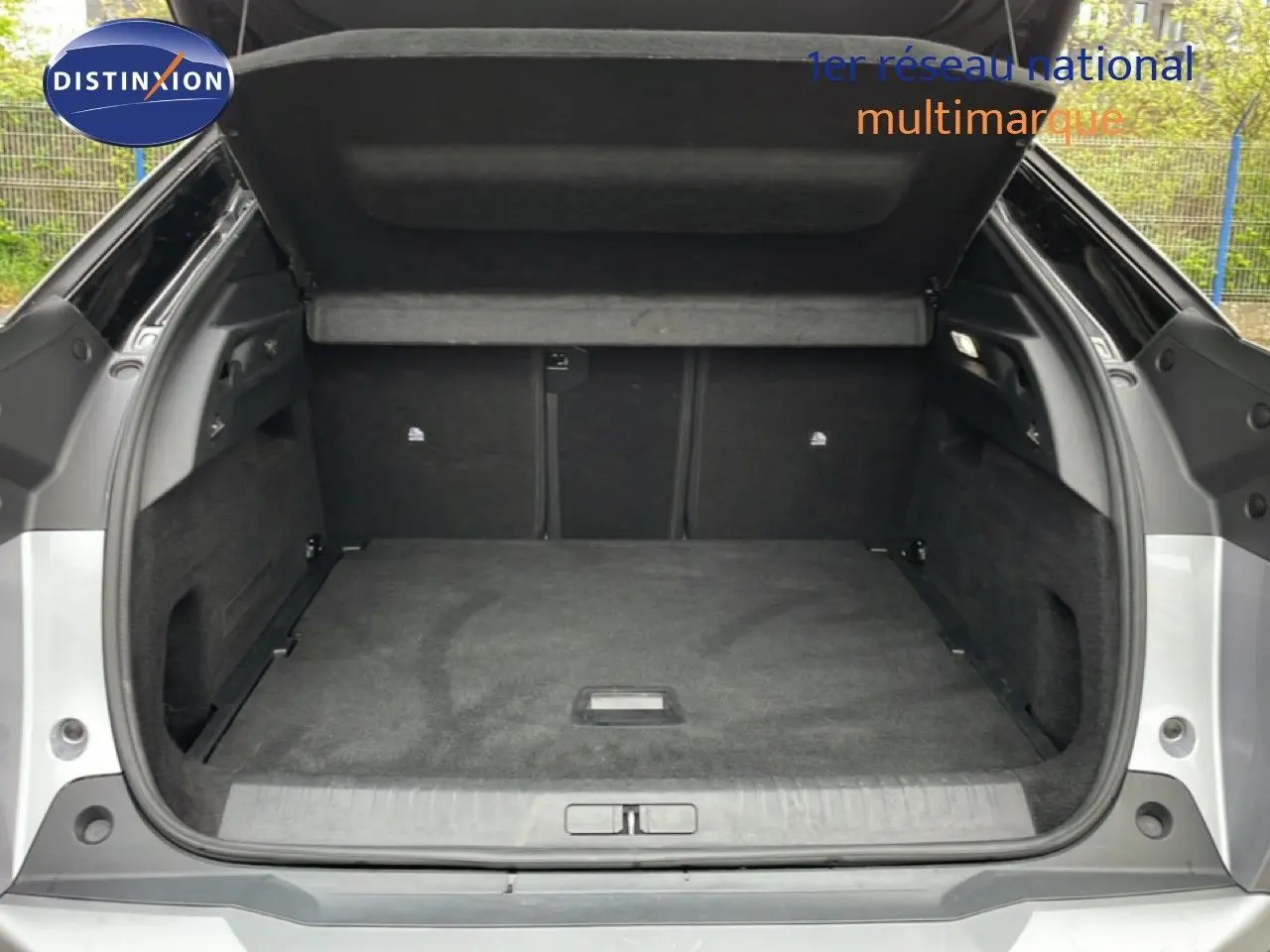 Coffre ouvert vu de l'arrière d'un Peugeot 3008 gris Artense Métal, montrant un espace de chargement propre et spacieux.