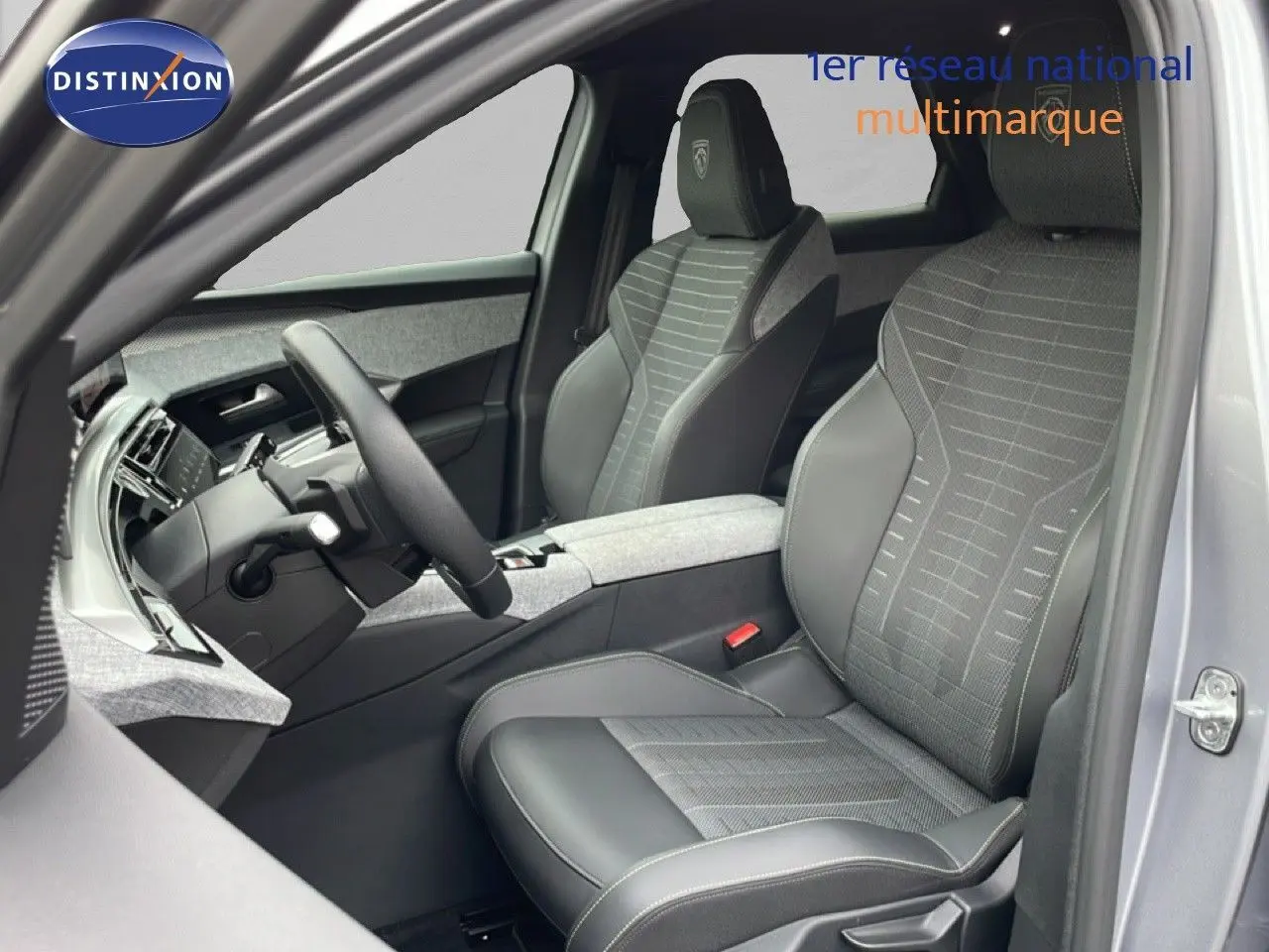 Vue intérieure côté conducteur du Peugeot 3008 gris Artense, mettant en valeur les sièges cuir et tissu avec logo GT brodé.