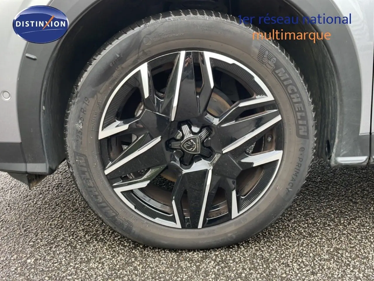 Gros plan sur la roue avant droite du Peugeot 3008 gris Artense Métal avec jante alliage noire et argentée.