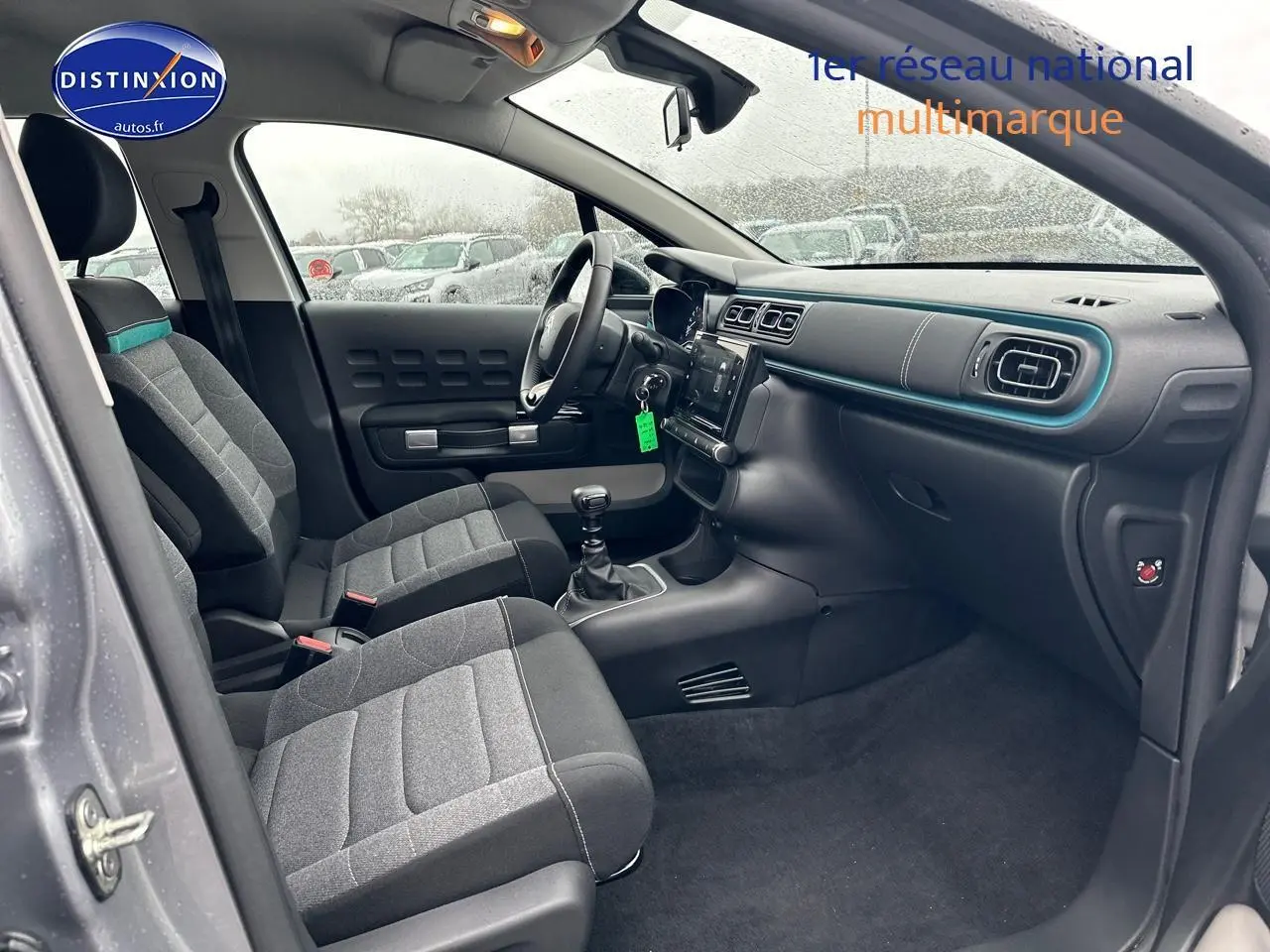 Vue intérieure côté conducteur de la Citroën C3 1.2 PureTech 110 gris acier, avec sièges tissu mica grey et tableau de bord moderne.