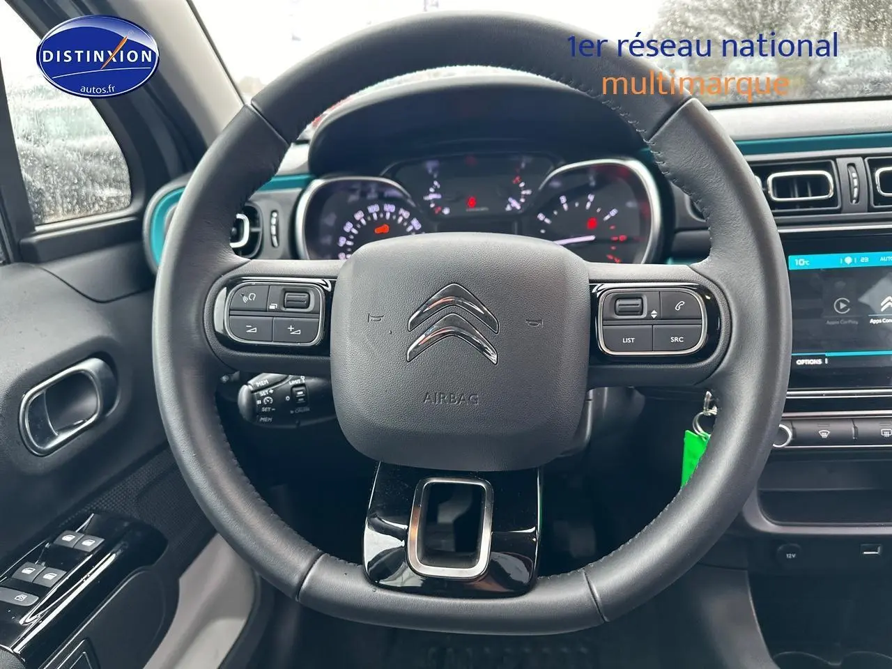 Vue intérieure centrée sur le volant noir d’une Citroën C3 2023 avec tableau de bord et écran tactile visible.