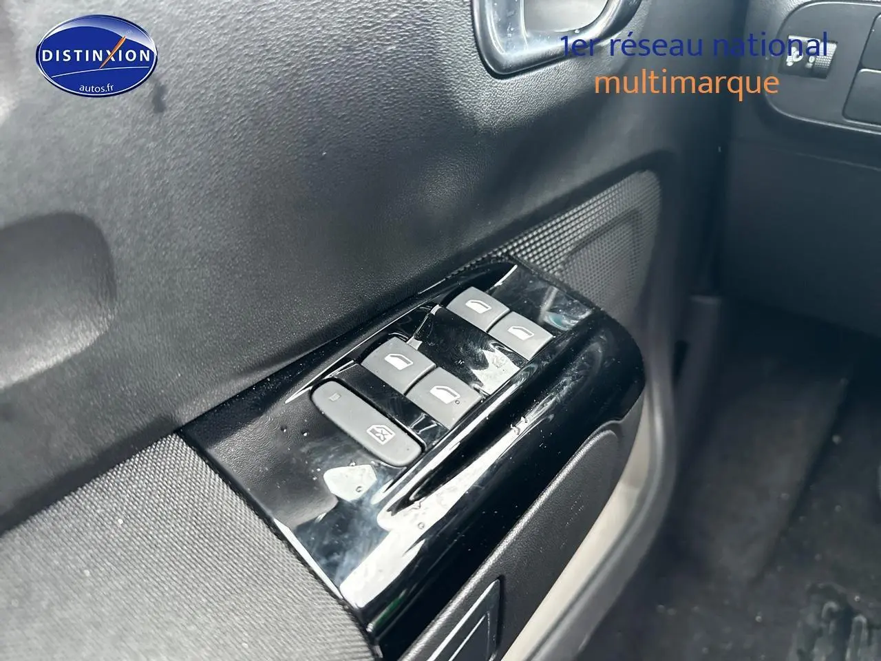 Gros plan sur les commandes de vitres électriques côté conducteur de la Citroën C3 gris acier 2023.