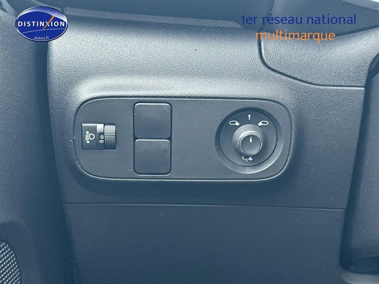 Gros plan sur les commandes noires de réglage des rétroviseurs côté gauche d'une Citroën C3 gris acier 2023.
