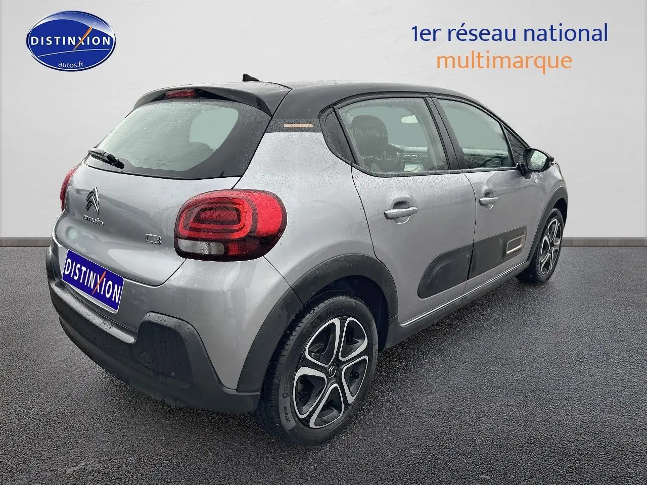 Vue 3/4 arrière droite d'une Citroën C3 gris acier avec toit noir et protections latérales noires.