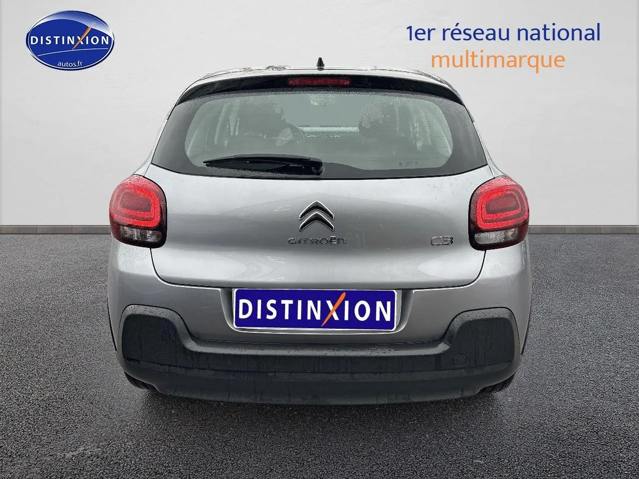 Vue arrière d'une Citroën C3 gris acier 2023 avec feux arrière allumés et pare-chocs noir.