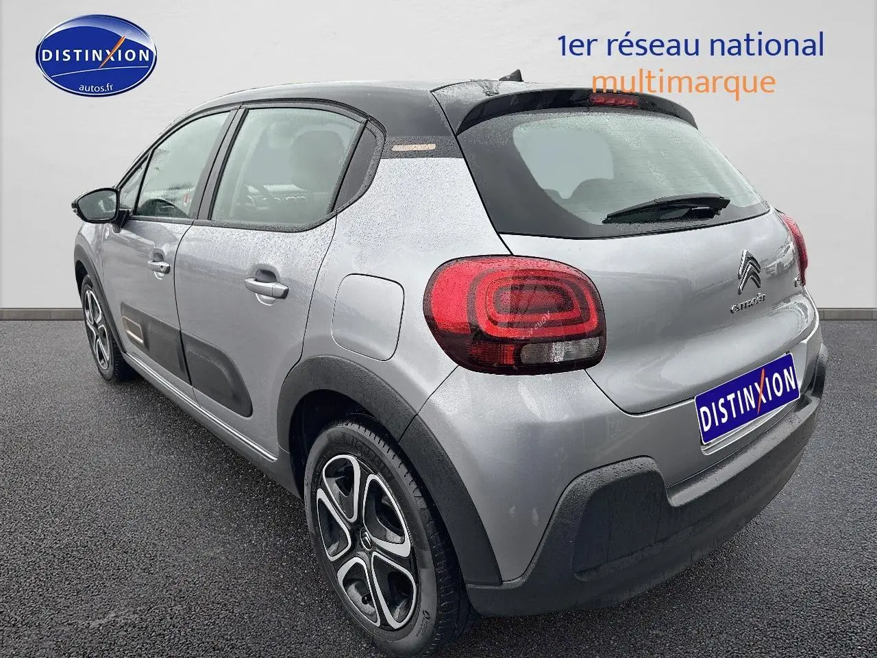 Vue 3/4 arrière droite d'une Citroën C3 gris acier avec feux arrière arrondis et protections noires sur les bas de caisse.