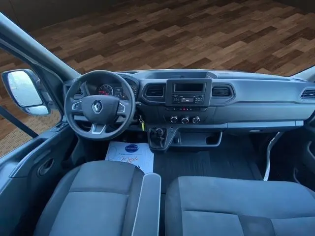 Vue intérieure du poste de conduite du Renault Master blanc 2022, avec tableau de bord simple et volant multifonctions.