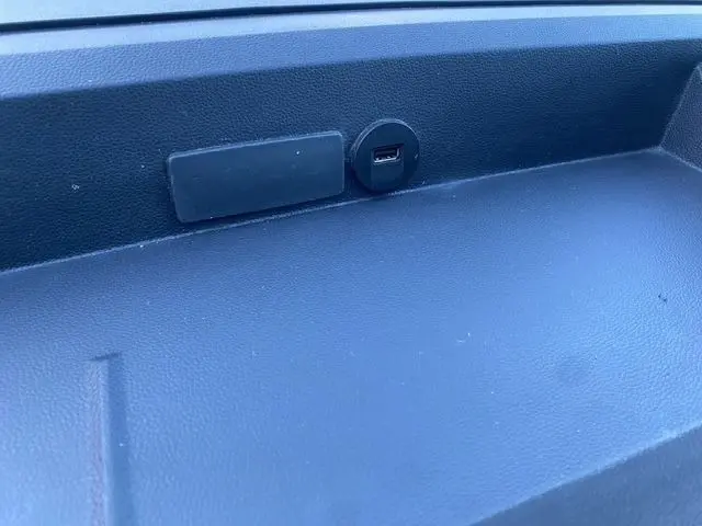 Gros plan sur la prise USB intégrée dans la planche de bord noire du Renault Master blanc, version utilitaire 2022.