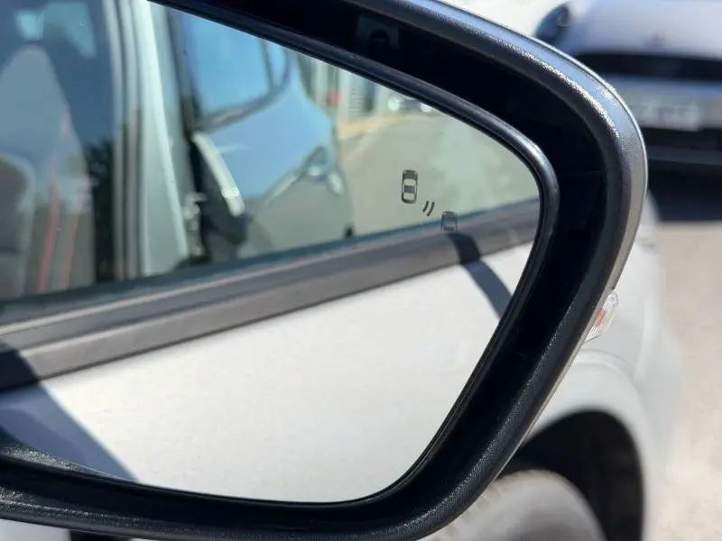 Rétroviseur extérieur côté gauche du Ford Kuga gris Solar Métallisée avec indicateur d'angle mort visible.