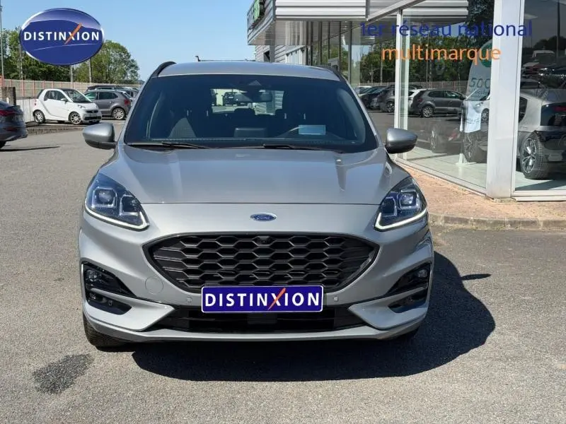 Vue avant d'un Ford Kuga 1.5 EcoBlue gris Solar métallisé avec calandre noire et phares LED distinctifs.