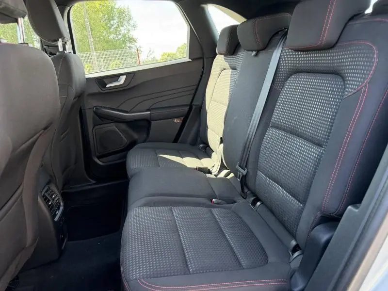 Vue latérale droite de la banquette arrière noire avec surpiqûres rouges du Ford Kuga 2023, intérieur spacieux et moderne.
