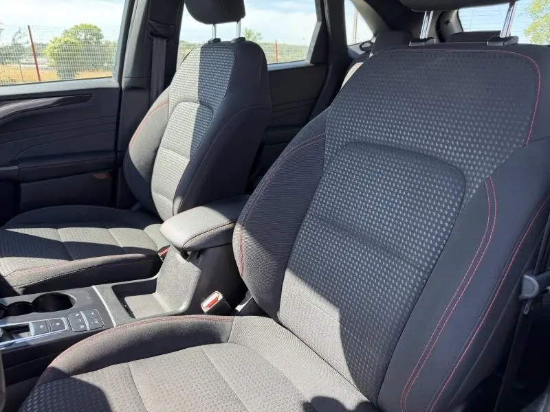Vue intérieure rapprochée des sièges avant sport noirs avec surpiqûres rouges du Ford Kuga 1.5 EcoBlue 2023.