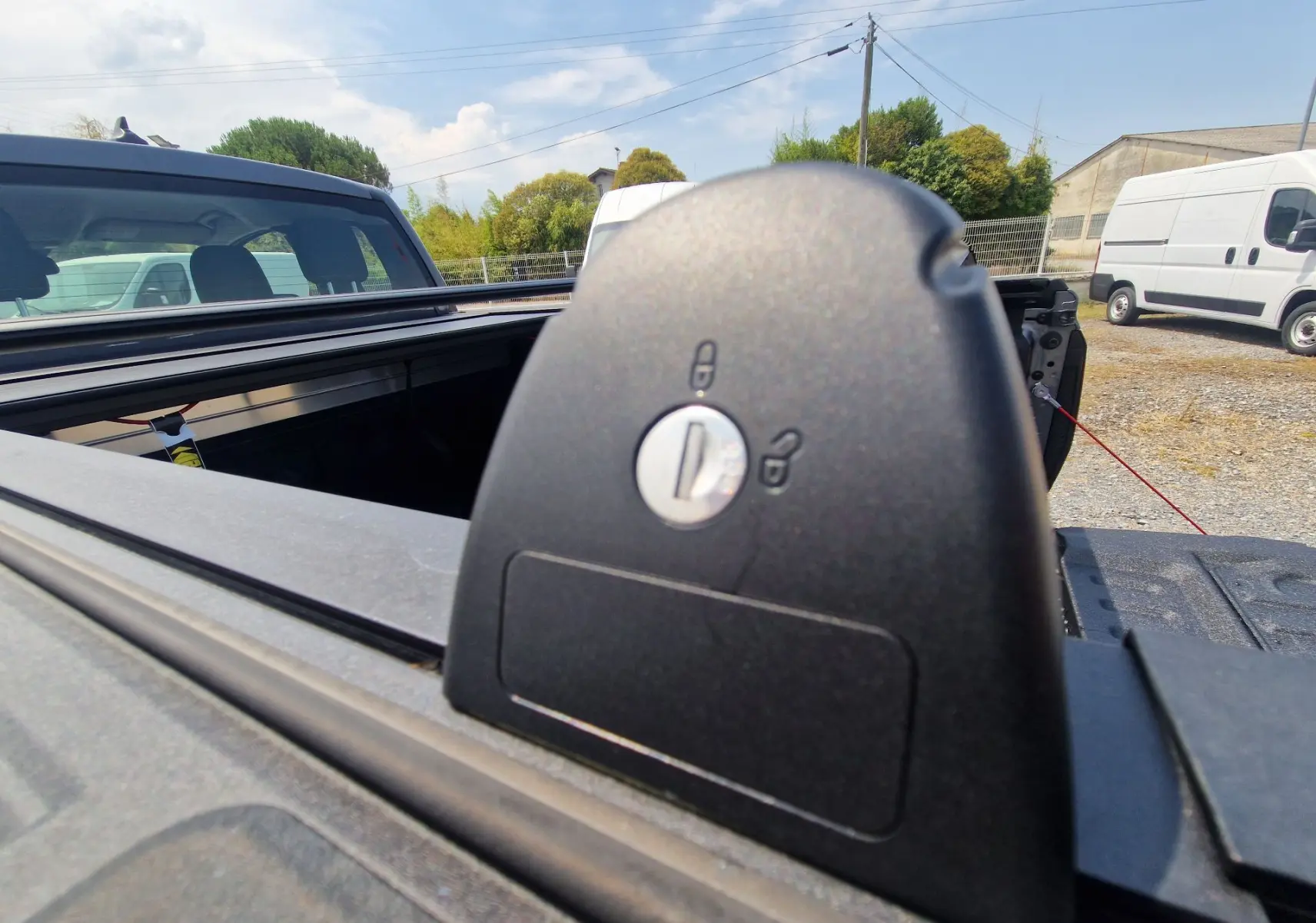 Gros plan sur le verrouillage du rideau de plateau rigide gris carbone du Ford Ranger Super Cabine, vue arrière extérieure.
