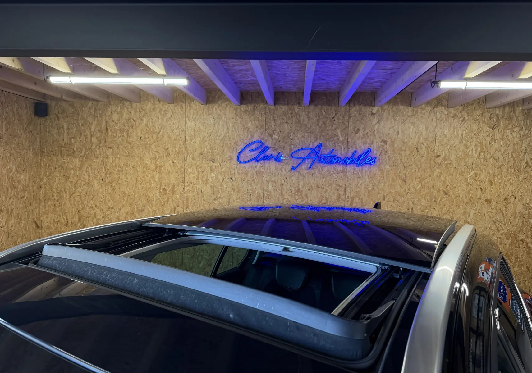 Toit ouvrant panoramique ouvert sur le dessus d’une Renault Mégane Estate noire, vue partielle en intérieur.
