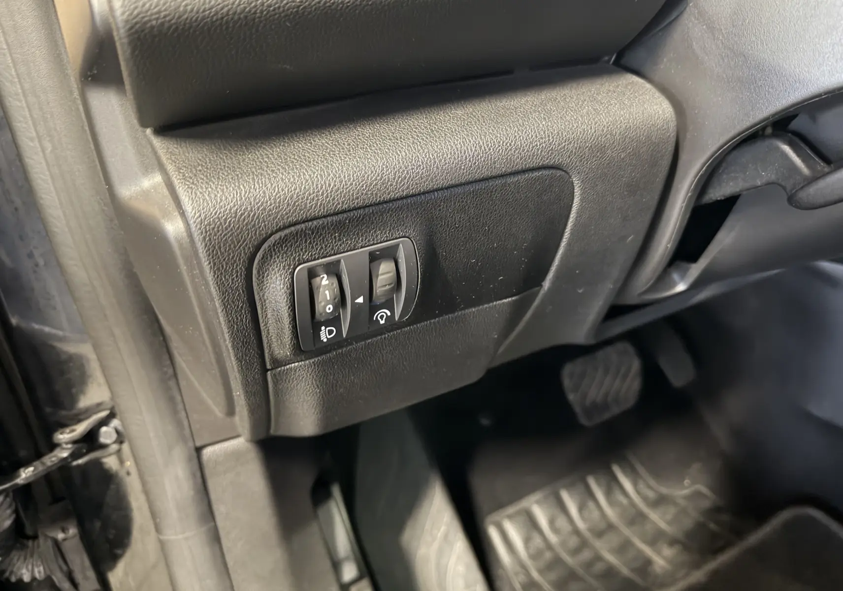 Vue rapprochée des commandes d’éclairage et tableau de bord côté gauche dans une Renault Mégane Estate noire 2024.