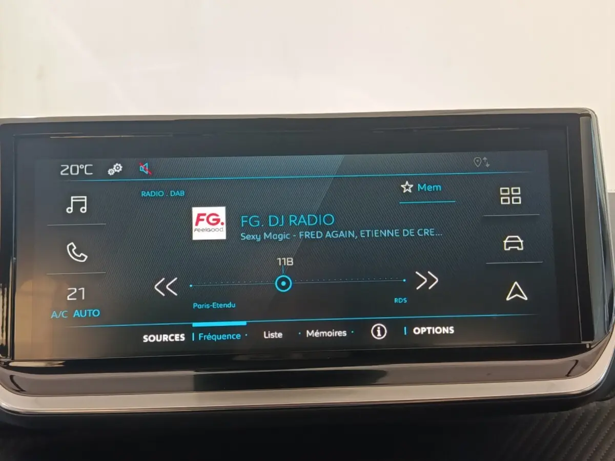 Écran tactile central de la Peugeot 208 électrique 2024 affichant la radio FG DJ en mode DAB, interface moderne.
