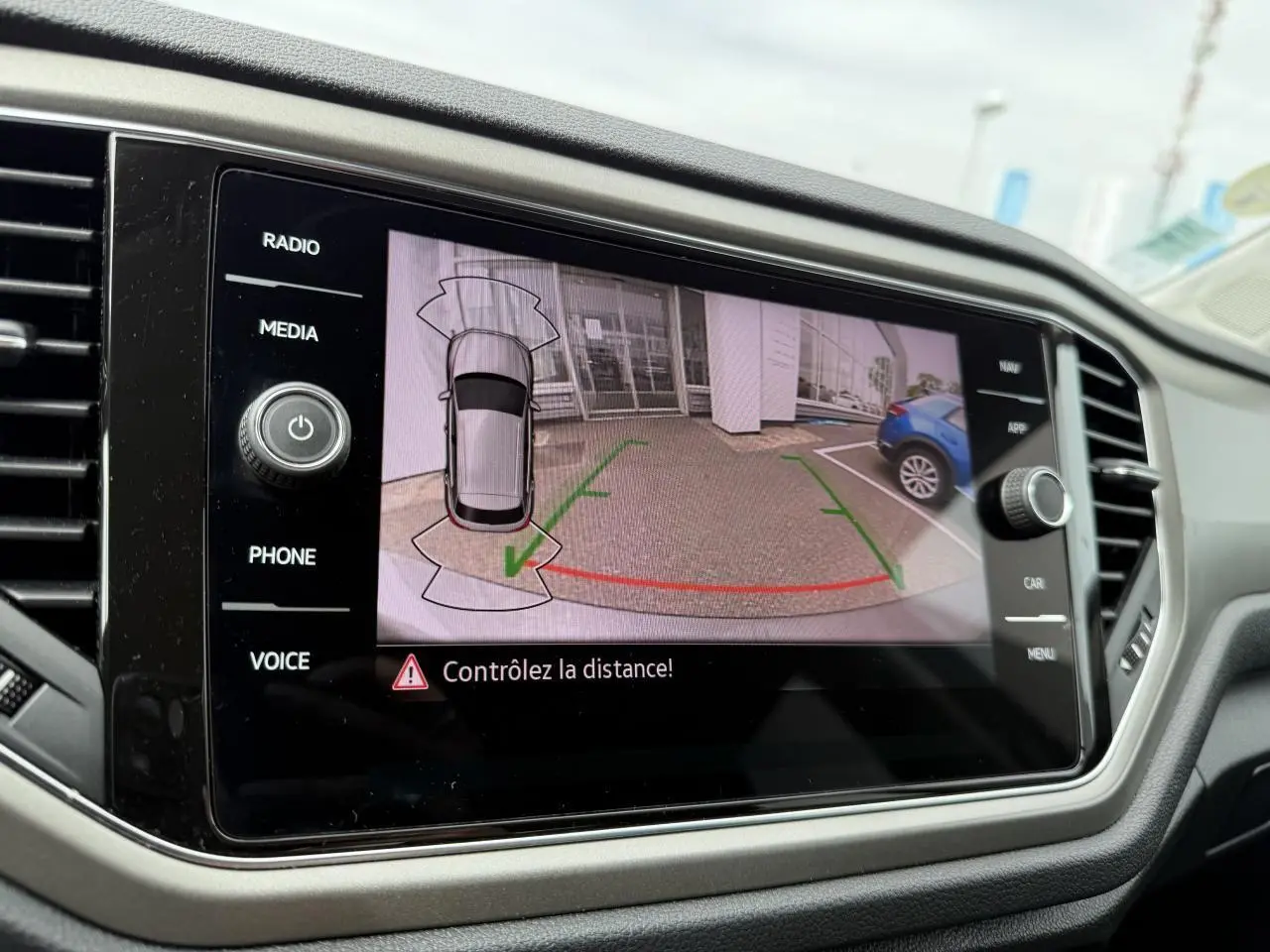 Écran multimédia du Volkswagen T-Roc 2021 montrant la caméra de recul avec vue arrière et alertes de distance.