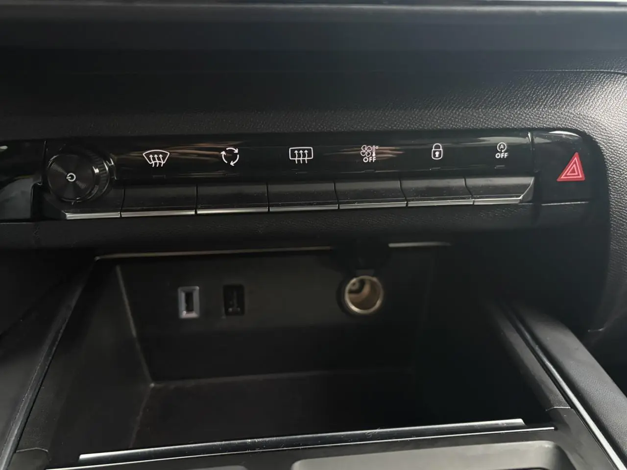 Vue rapprochée de la console centrale noire du Citroën C5 Aircross Hybrid 2024, avec commandes et prises USB visibles.