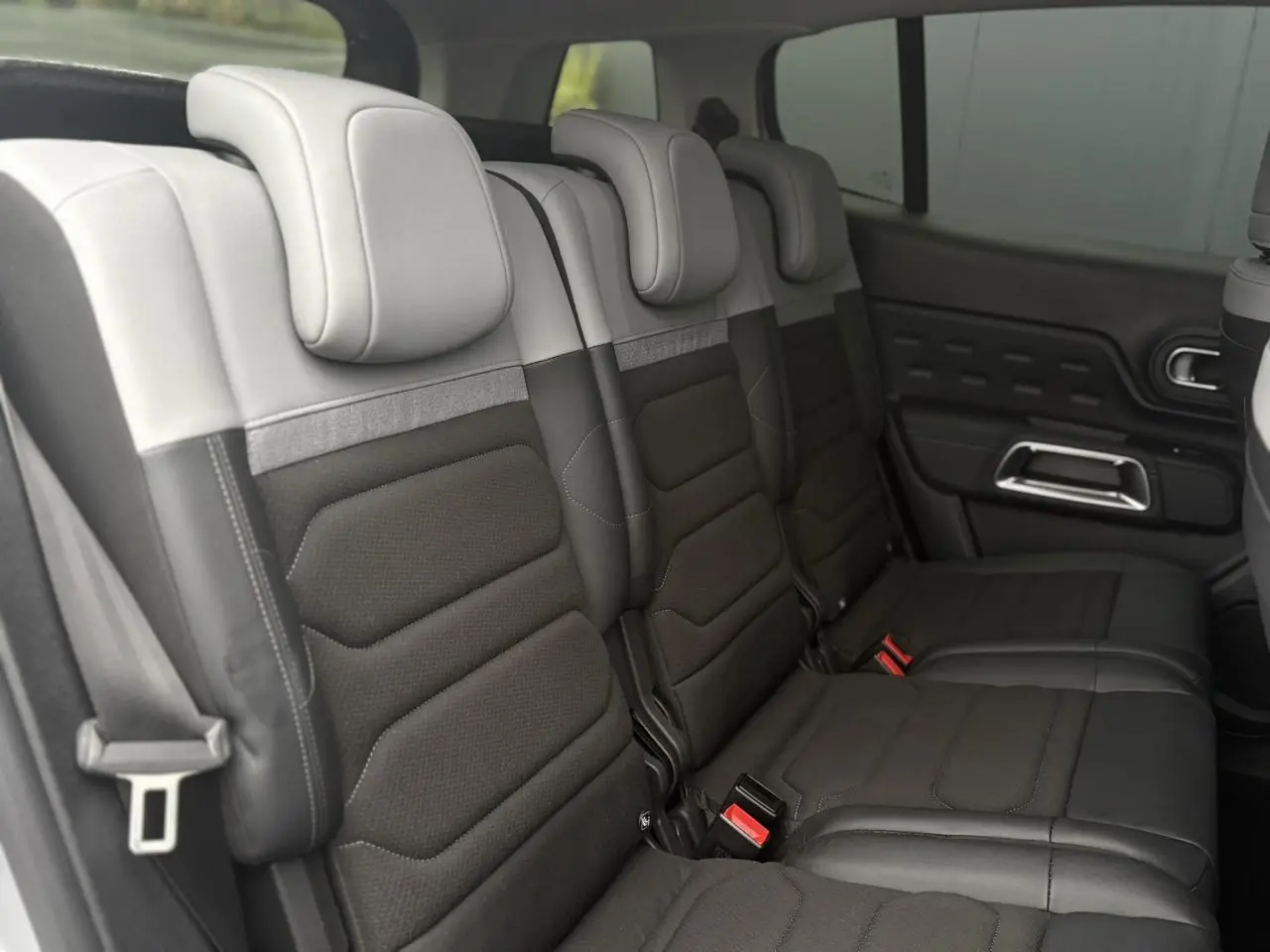 Vue latérale des trois sièges arrière indépendants gris clair et noir du Citroën C5 Aircross Hybrid 2024.